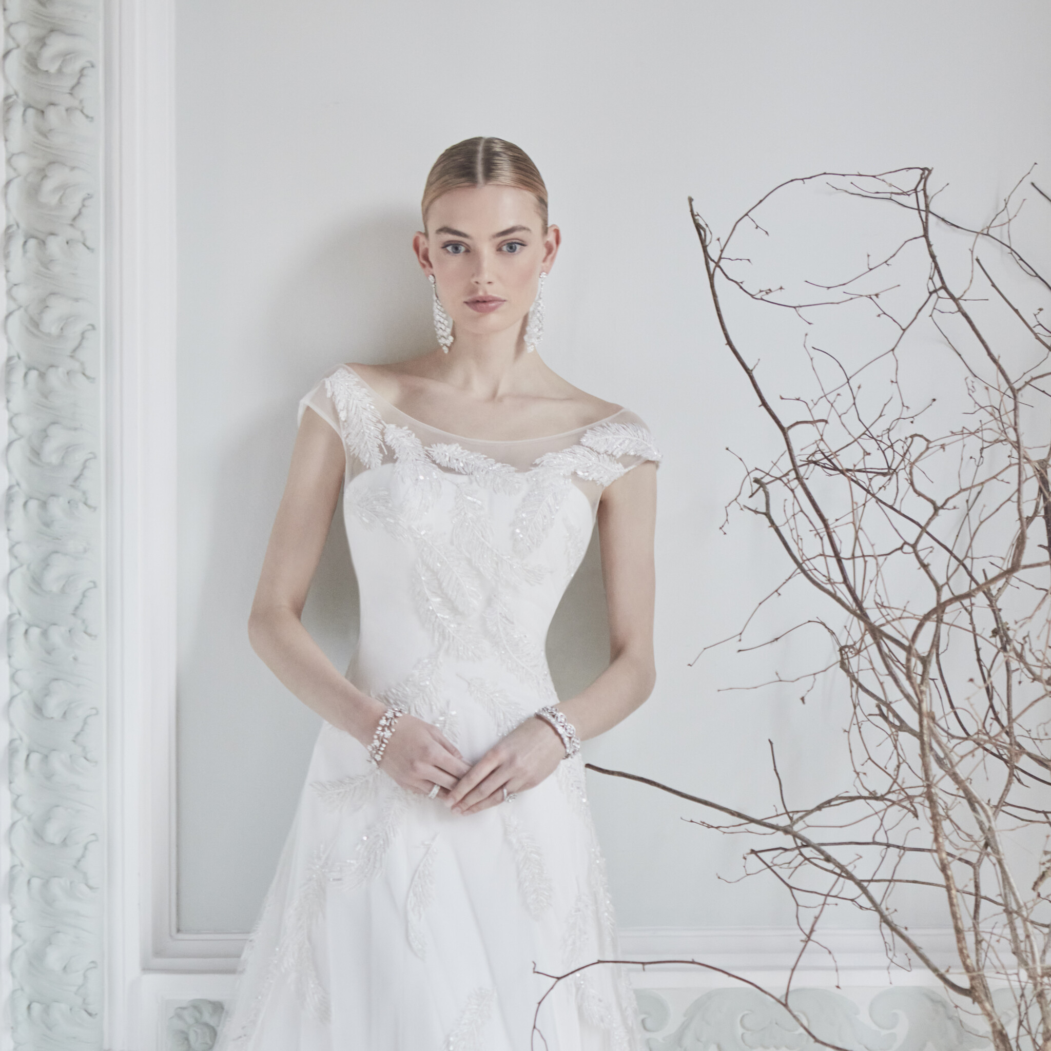 Phillipa Lepley Couture Wedding Dress London Nude Tallulah Crepe With Falling Feathers Overlay strapless crepe princess-line wedding gown worn with scoop neckline tulle cap sleeve overlay with hand embroidered beaded sparkle feathers
